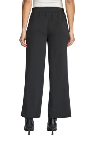 Black wide-leg cropped pants shown from the back on a model, paired with black pointed-toe heels against a light gray studio background.