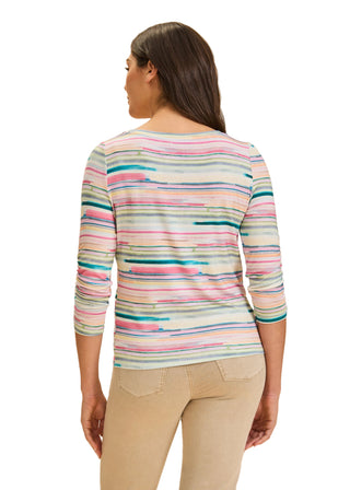 Woman wearing a colorful striped shirt against a beige background