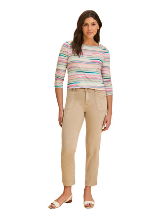Woman wearing a striped sweater and beige pants on a beige background