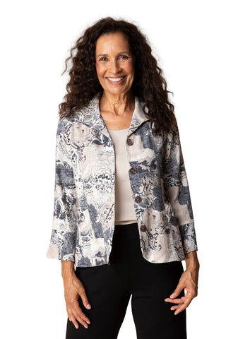 Woman wearing a patterned jacket over a white shirt and black pants on a beige background