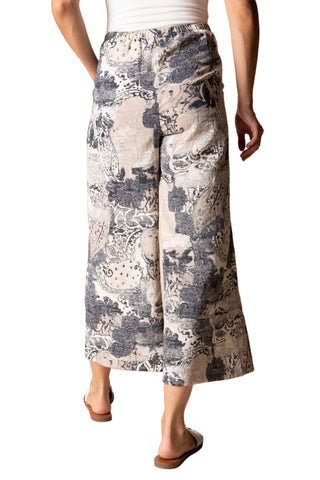 Person wearing a patterned skirt on a beige background