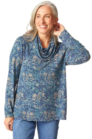 Woman wearing a blue patterned long-sleeve top on a white background