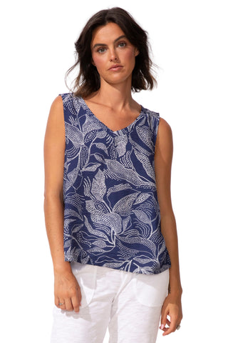 Woman wearing a blue leaf-patterned top on a white background