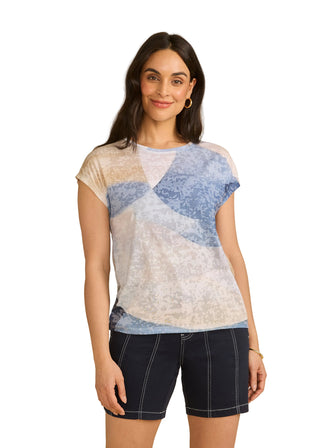 Woman wearing a patterned top and black shorts on a beige background