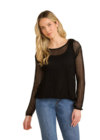 Woman wearing a black knit sweater with sheer sleeves against a beige background