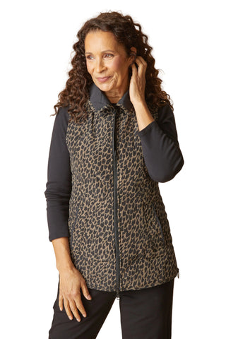 Woman wearing a leopard print vest over a black shirt on a beige background