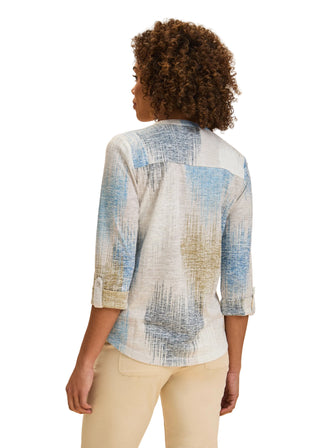 Woman wearing a patterned shirt with a beige background