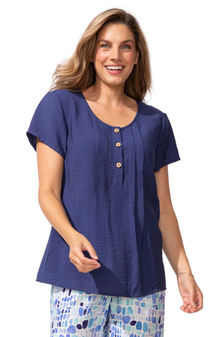 Woman wearing a blue top with button details on a white background