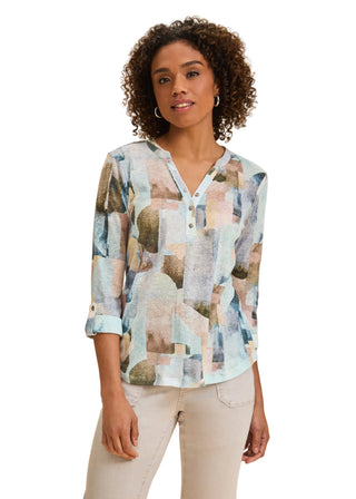 Woman wearing a patterned blouse against a beige background