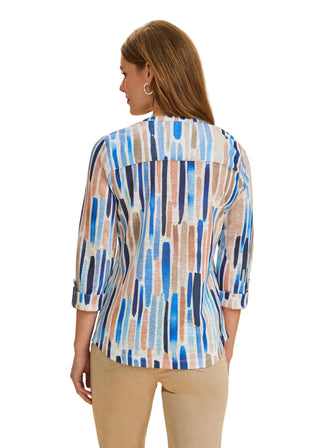 Woman wearing a colorful patterned shirt against a beige background