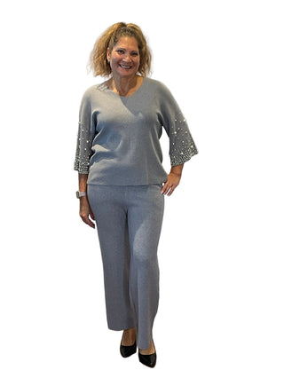 Woman in a gray outfit standing in front of an 'Anne's on the Avenue' sign.
