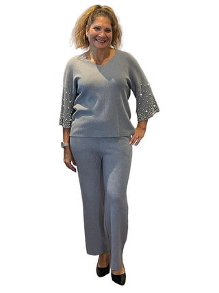 Woman in a gray outfit standing in front of an 'Anne's on the Avenue' sign.