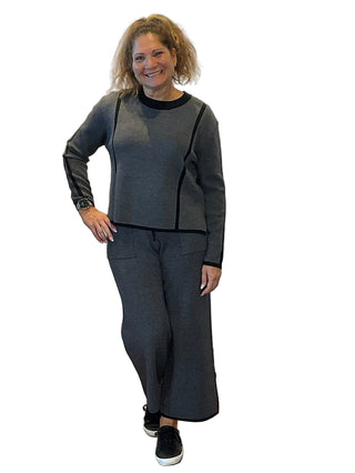 Woman in gray outfit standing in front of a 'Anne's on the Avenue' backdrop.