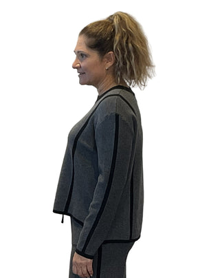Woman wearing a gray outfit with black trim against a white background