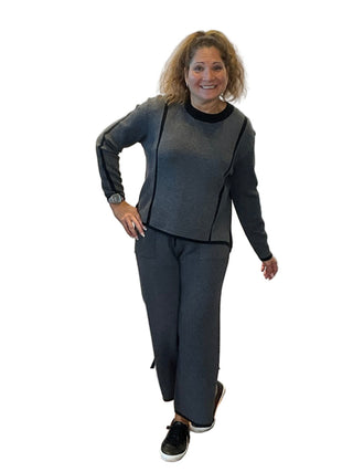 Woman posing in front of a branded backdrop with 'Anne's on the Avenue' logo.