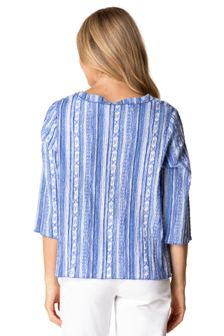 Woman wearing a blue patterned top against a beige background