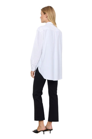Woman wearing a white shirt and black pants on a plain background
