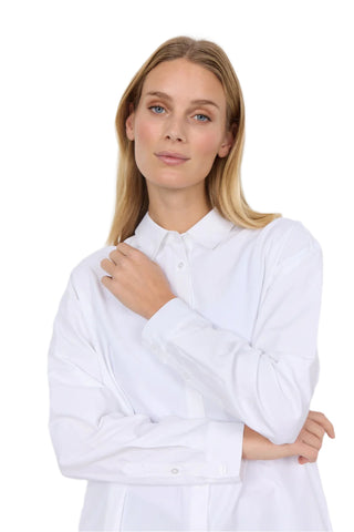 Woman wearing a white shirt against a plain background