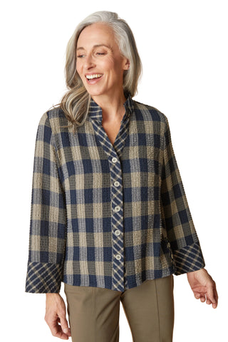 Woman wearing a blue and beige plaid shirt against a beige background