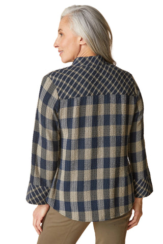 Woman wearing a blue and beige plaid jacket on a beige background