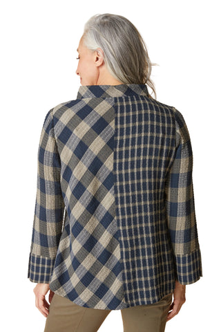 Person wearing a blue and beige plaid jacket on a beige background