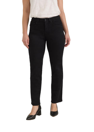 A model wearing black slim-fit jeans with a white sleeveless top and black pointed-toe heels, standing against a light gray studio background.