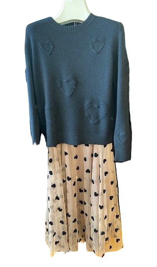 Dark blue sweater with heart patterns on a mannequin in a store setting.