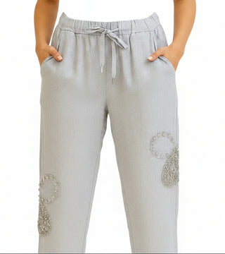 White pants with embellishments on a white background