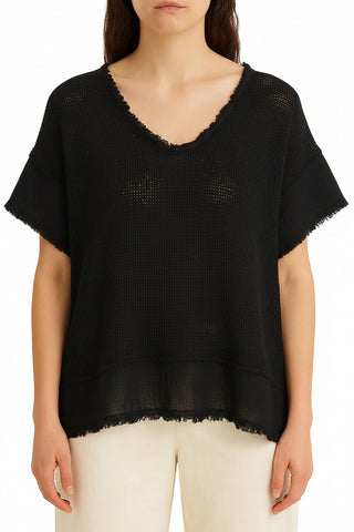 Woman wearing a light beige mesh top and pants against a white background