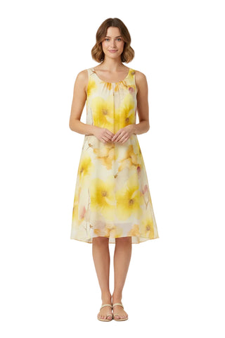 Woman wearing a yellow floral dress on a white background