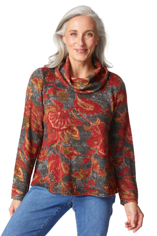 Woman wearing a colorful floral-patterned sweater against a white background