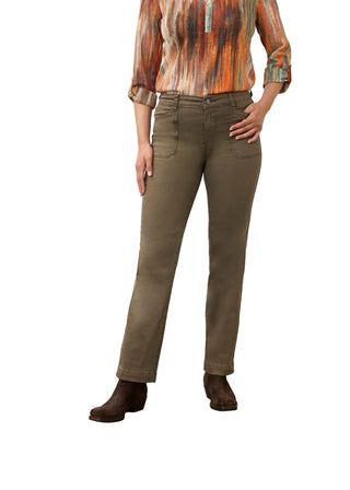 A model wearing olive green straight-leg jeans, a multicolor orange and brown patterned long-sleeve shirt, and dark brown suede boots, standing against a neutral studio backdrop.
