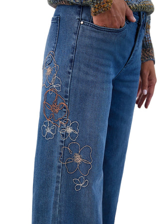 Blue jeans with floral embroidery on a white background