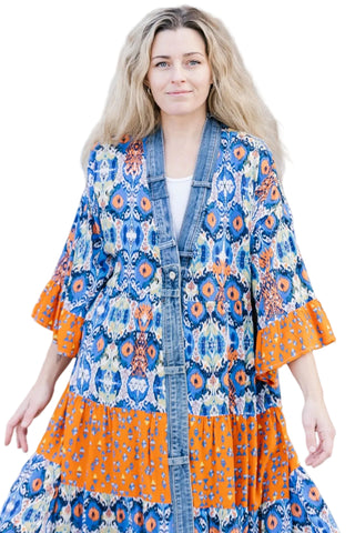 Woman wearing a colorful kimono-style dress with a pattern of blue, orange, and white.