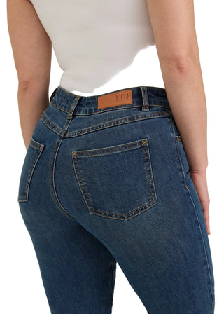 Rear view of a person wearing blue denim jeans with a white top, showing the back pocket and waistband details against a plain light background.
