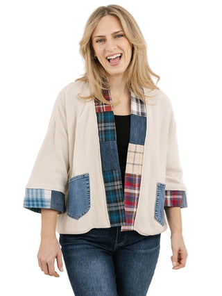Woman wearing a beige jacket with plaid accents on a white background