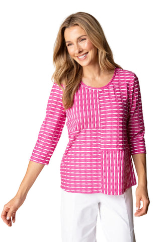 Woman wearing a pink and white striped top with a beige background
