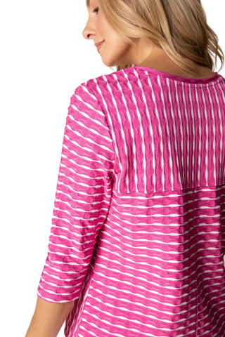 Woman wearing a pink and white striped shirt against a beige background