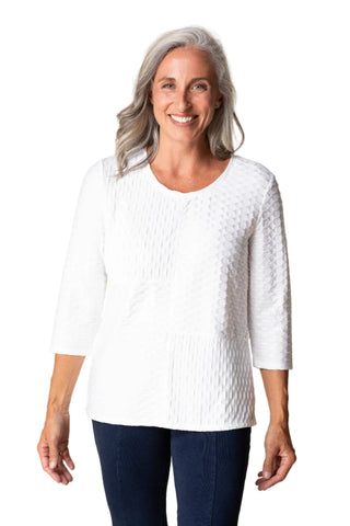 Woman wearing a white textured sweater against a beige background
