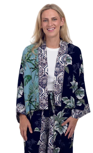 Woman wearing a navy blue kimono with tropical leaf pattern on a white background