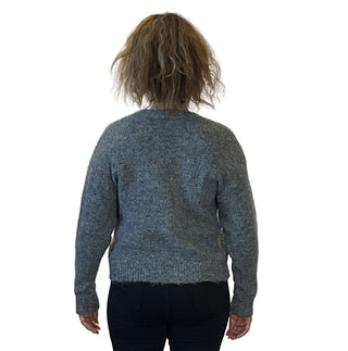 Person wearing a gray sweater against a white background