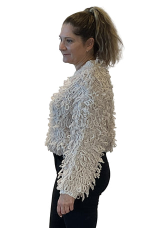 Woman wearing a textured white jacket against a plain background