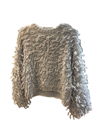 Textured gray sweater on a hanger in a store setting