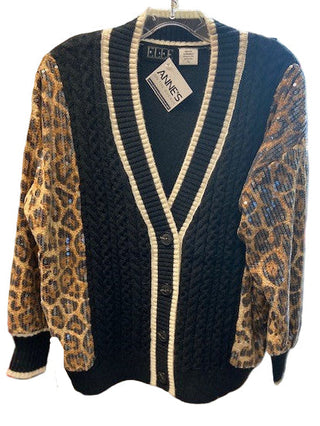 Black cardigan with leopard print sleeves on a hanger in a store setting
