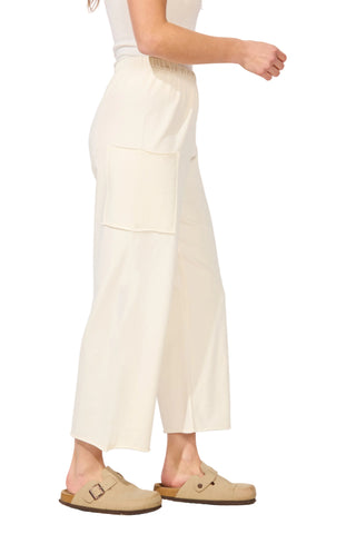 Person wearing light-colored pants and beige shoes on a white background