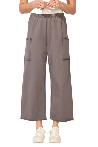 Person wearing gray cargo pants on a white background