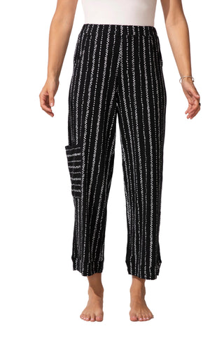 Person wearing black and white striped pants on a white background