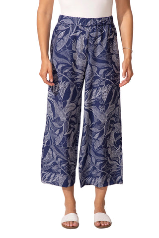 Person wearing blue leaf-patterned pants on a white background