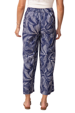 Person wearing navy blue pants with white leaf pattern on a white background