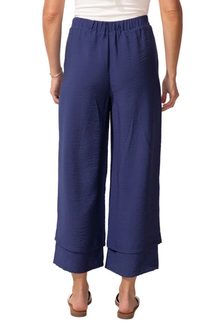 Person wearing navy blue wide-leg pants on a white background